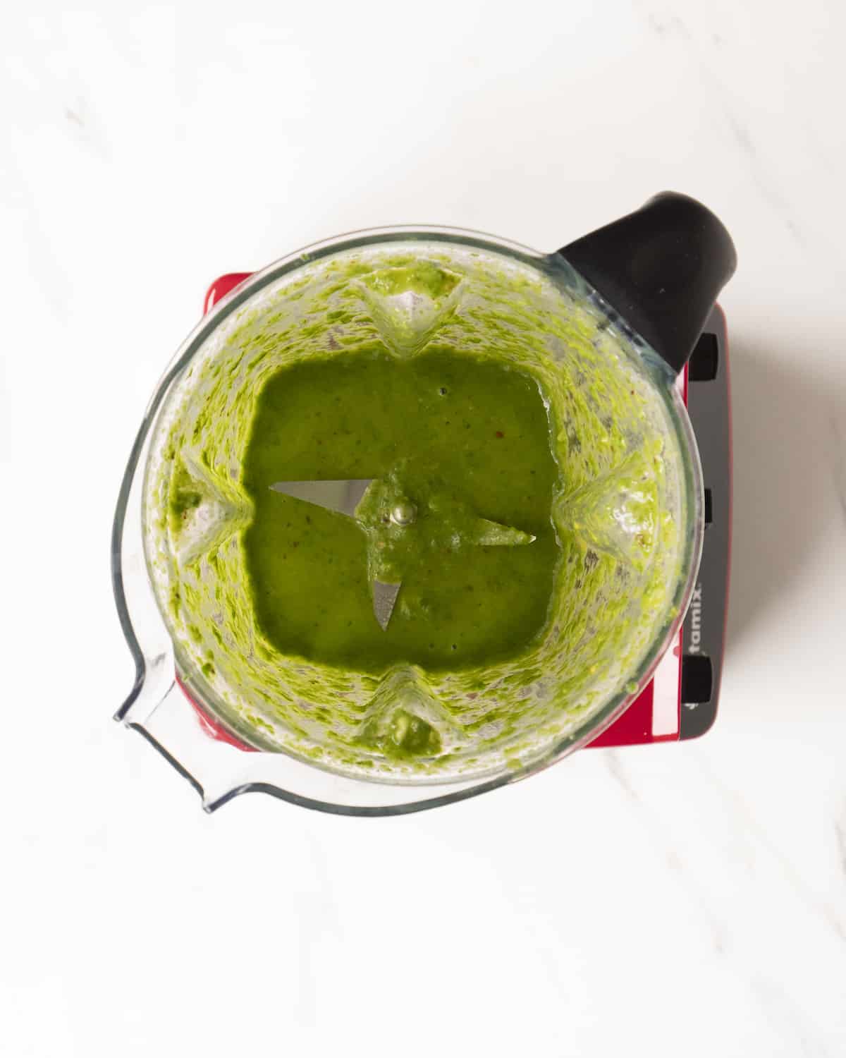 Blended basil vinaigrette in a food processor.