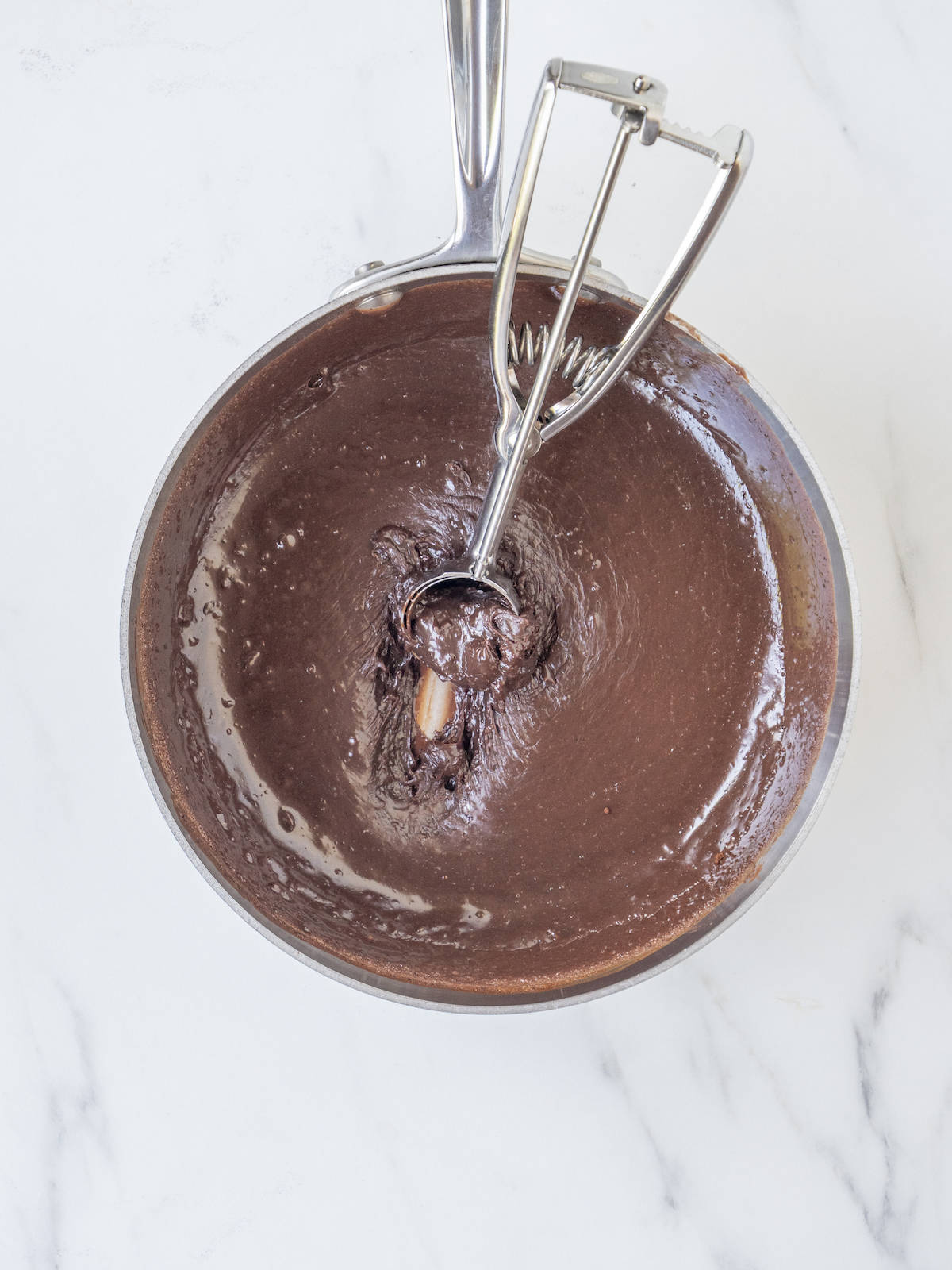 A saucepan with thick mixture made of cocoa powder, condensed milk and butter.