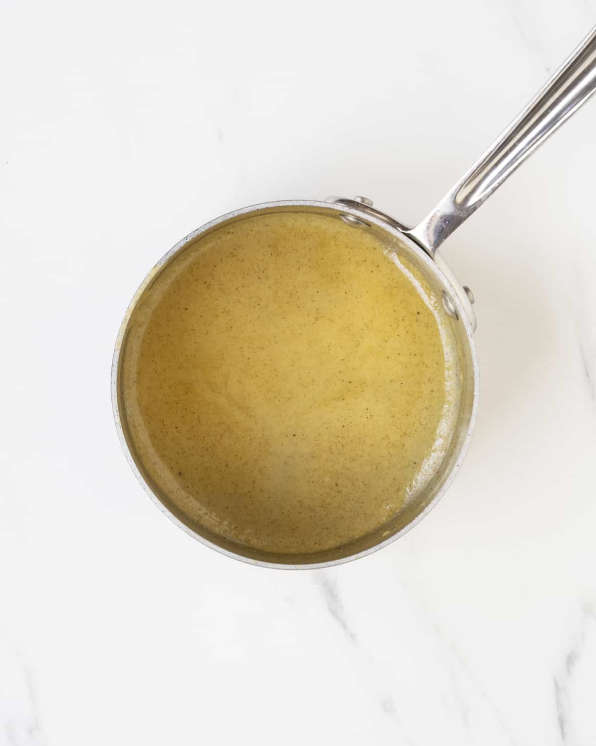 The reserved sauce from the cooked off chicken is is in a pot.  