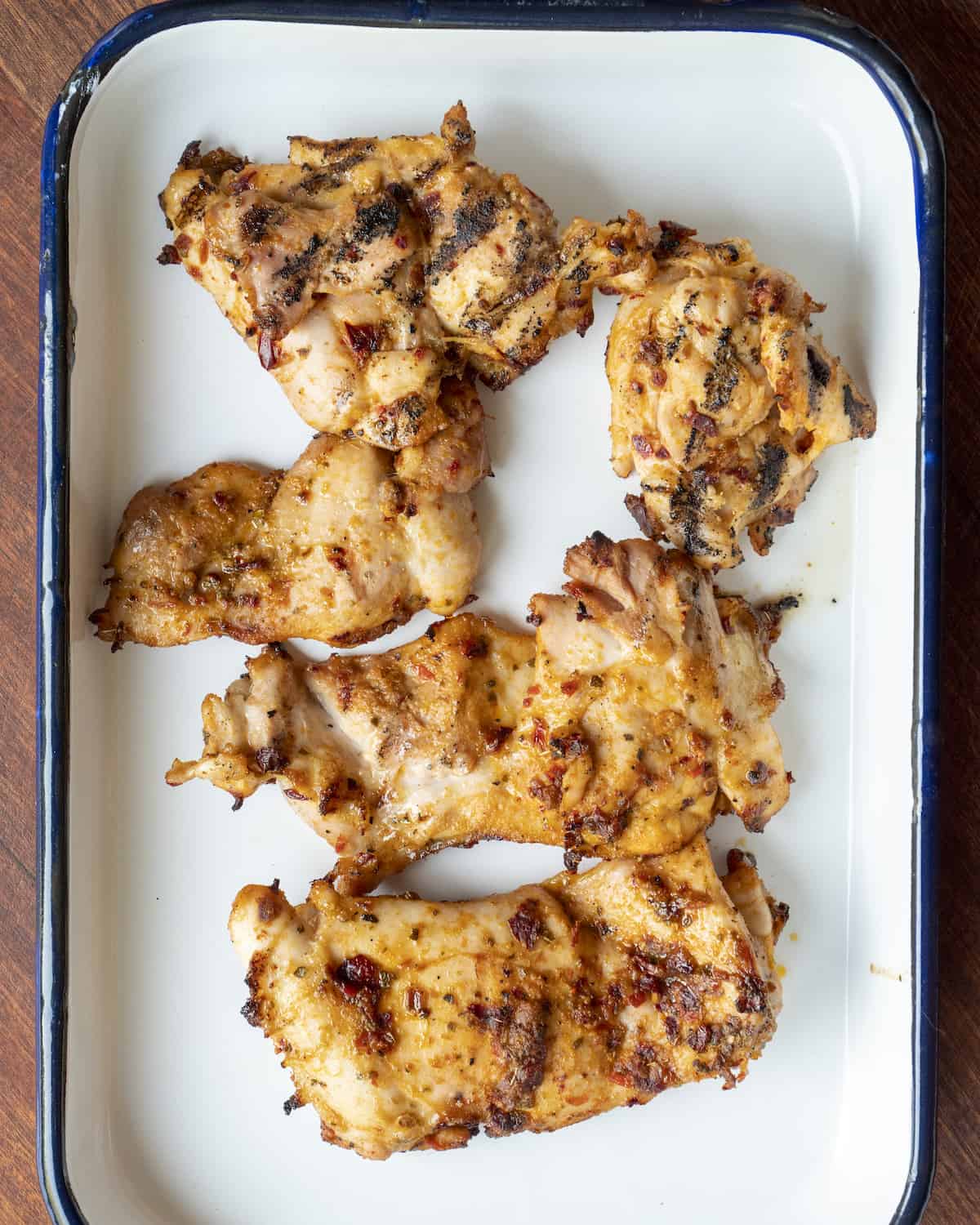 Cooked and seasoned chicken in a white baking dish.