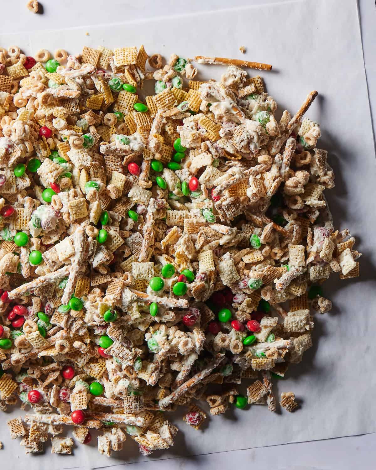 Parchment paper on a white kitchen counter with christmas mix on it.